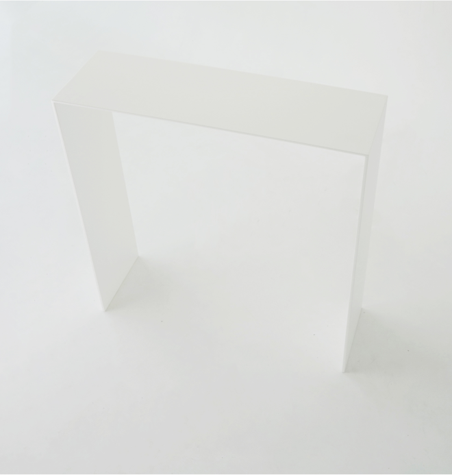 A minimalist white U shape console with a thin rectangular top and two thicker straight legs.