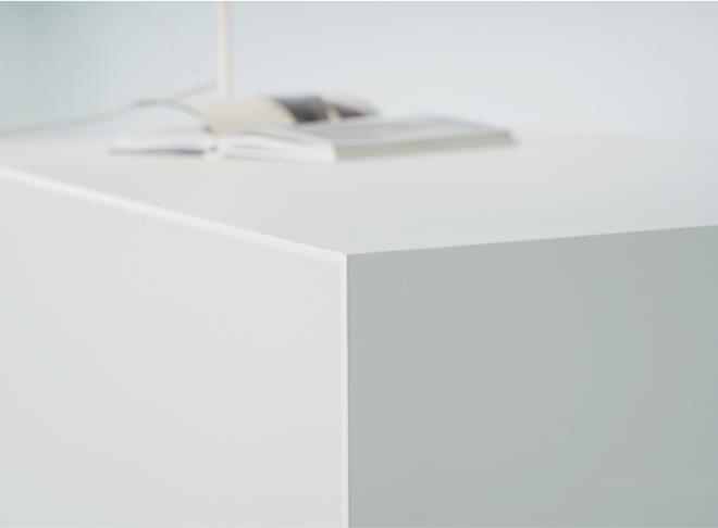 A detail of straight edges on the U shape white desk.
