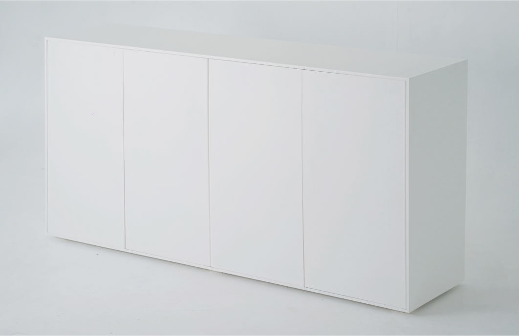 A wide shot of a minimalist white sideboard. The front features four closed doors, each flush with the overall structure.