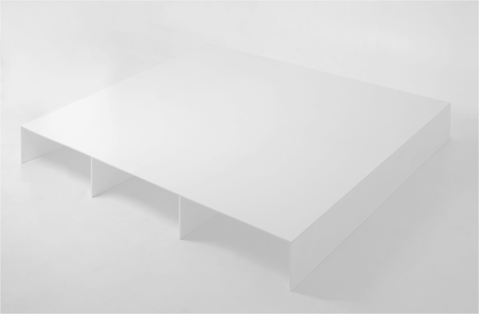 A minimalist white U shape bench and a table. The bench is positioned directly above the table.