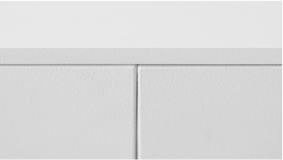 A close-up detail of the minimal spacing between the doors of a white sideboard.