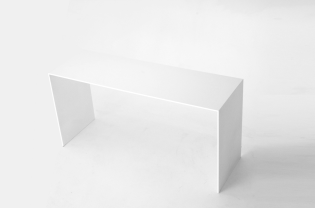 U shaped bench made out of solid aluminum plates and coated in white. 