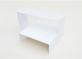 A minimalist white U shape bench and a table. The bench is positioned directly above the table. 