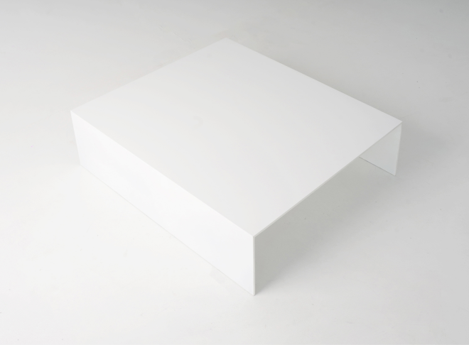 A wide overhead angle of a white rectangular table facing right. A single piece, bent at the edges to form a sharp U-shape.